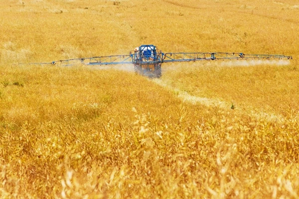 agrochimie épandage de pesticides sur un champ de céréales